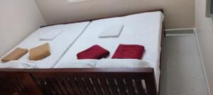 a white bed with two red pillows on it at Guru Room in Tiruvannāmalai +7 photos