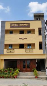a building with a sun rooms sign on it at Guru Room in Tiruvannāmalai