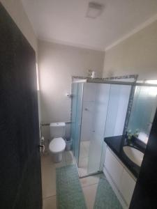 a bathroom with a toilet and a sink and a shower at Sobrado Mobiliado in Três Lagoas +17 photos