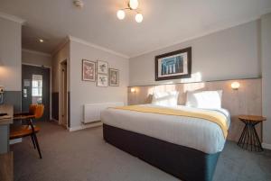 ein Hotelzimmer mit einem großen Bett und einem Schreibtisch in der Unterkunft Highfield Hotel in Houghton le Spring