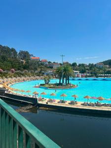 a large swimming pool with chairs and umbrellas at Sobrado das Marias in Figueiró dos Vinhos