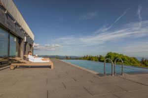a woman laying on a bed next to a swimming pool at Hochblauen Hotel in Badenweiler