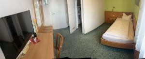 a small room with a bed and a television at Hotel Deutsches Haus in Lampertheim