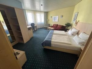 a hotel room with a bed and a living room at Hotel Deutsches Haus in Lampertheim
