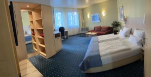 a hotel room with a large bed and a living room at Hotel Deutsches Haus in Lampertheim