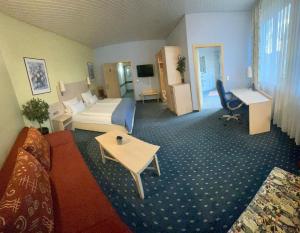 a hotel room with a bed and a living room at Hotel Deutsches Haus in Lampertheim +19 photos