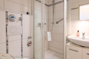a bathroom with a shower and a sink at Waterkant in Schilksee