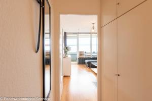a hallway with a door leading to a living room at Waterkant in Schilksee