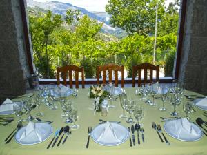 a table with glasses and utensils on top of it at A Cobiça do Mundo in Pincães