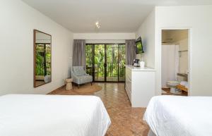 ein Hotelzimmer mit zwei Betten und einem Badezimmer in der Unterkunft Boutique Surf Hotel Rip Jack Inn in Playa Grande + 69 Fotos