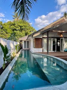 a swimming pool in front of a house at Captain Goodtimes in Gili Islands