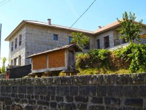a house sitting on top of a stone wall at A Cobiça do Mundo in Pincães