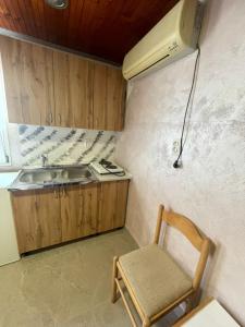 a small kitchen with a sink and a chair at Apartman Metovic in Bar