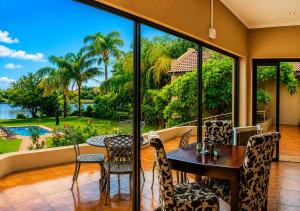 a dining room with a table and chairs and a large window at Moonriver Guesthouse in Upington