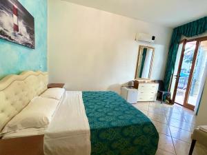 a bedroom with a bed and a dresser and a window at Residence Perla - Salve in Salve