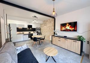 a living room with a couch and a table with a fireplace at Le Grainetier in Margny-lès-Compiègne