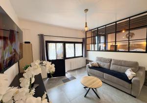 a living room with a couch and a table at Le Grainetier in Margny-lès-Compiègne