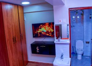 a bathroom with a fire painting on the wall at Branson Comfort Inn in Kakamega