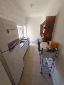 a kitchen with a refrigerator and a table in it at Casa Aconchegante e Mobiliada in Três Lagoas