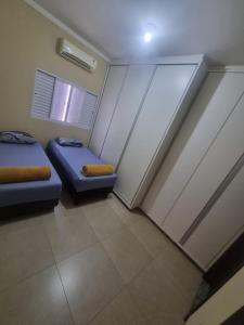 a small room with two beds and a window at Casa Aconchegante e Mobiliada in Três Lagoas