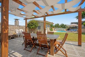 a patio with a table and chairs under a pergola at Casa Da Redouça in Cedrim