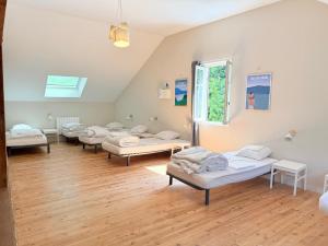 a room with several beds in it with a window at La maison du lac in Vions