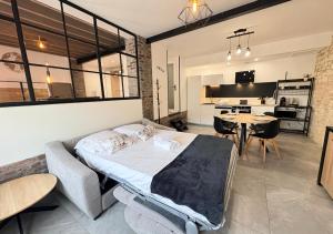 a bedroom with a bed and a table and a kitchen at Le Grainetier in Margny-lès-Compiègne