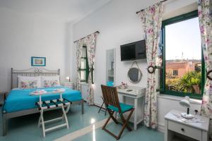 a bedroom with a bed and a desk and a window at Medieval Inn in Rhodes Town