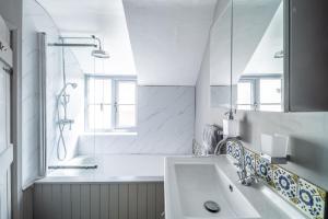 a white bathroom with a sink and a shower at Ruthie Cottage in Bacton +31 photos