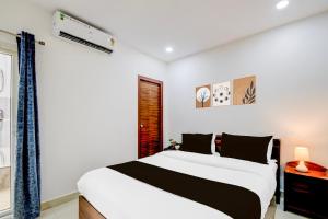 a bedroom with a large bed and a window at Super Townhouse Nallagandla Nest in Hyderabad