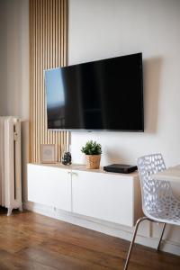 a living room with a tv on a white dresser at LE RIVA - Studio Hyper Centre - Parking - Wifi in Menton