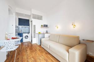 a living room with a couch and a kitchen at LE RIVA - Studio Hyper Centre - Parking - Wifi in Menton
