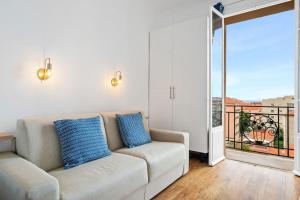 a living room with a couch and a balcony at LE RIVA - Studio Hyper Centre - Parking - Wifi in Menton
