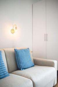 a couch with two blue pillows in a living room at LE RIVA - Studio Hyper Centre - Parking - Wifi in Menton +27 photos