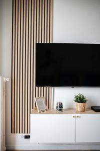 a flat screen tv on top of a white cabinet at LE RIVA - Studio Hyper Centre - Parking - Wifi in Menton
