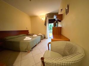 a hotel room with a bed and a chair at Residence Perla - Salve in Salve +14 photos