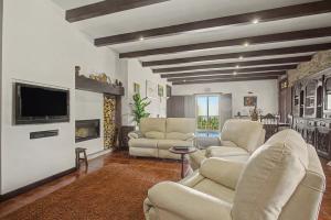 a living room with white furniture and a flat screen tv at Casa Da Redouça in Cedrim