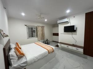 a bedroom with a bed and a flat screen tv at S L N paradise in Chik Bānavar