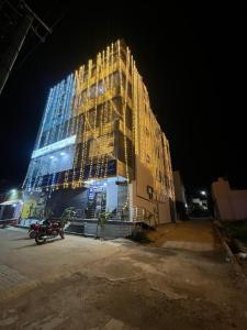 a tall building is lit up at night at S L N paradise in Chik Bānavar