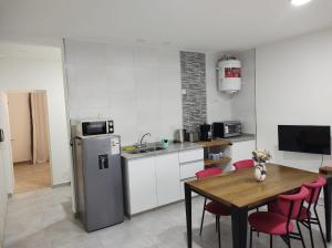 a kitchen with a table and a refrigerator at Departamento Alquiler Temporal en Chascomús in Chascomús