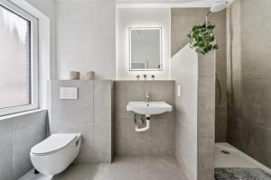 a white bathroom with a toilet and a sink at Boardinghouse Rees in Rees