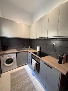 a kitchen with white cabinets and a washing machine at Anassa Homes Leros in Agia Marina