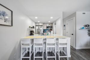 a kitchen with a white table and white chairs at Carolina Beach Ocean Playground in Carolina Beach