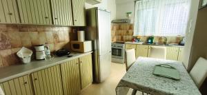 a small kitchen with a table and a refrigerator at Mama's Home in Chios