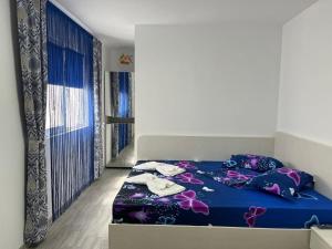 a bedroom with a bed with a blue comforter at Casa Inna Inna Corbu in Corbu
