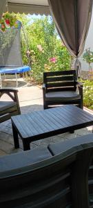 two benches and a picnic table with an umbrella at Casa Inna Inna Corbu in Corbu