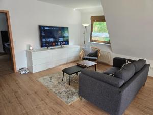 a living room with two couches and a flat screen tv at Ferienwohnung am Hainer Berg in Heigenbrücken
