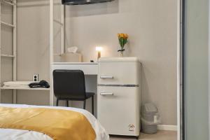 a room with a refrigerator and a desk with a chair at Seoul Jongno Hostel in Seoul