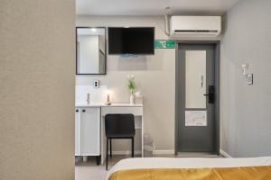 a room with a bed and a desk with a television at Seoul Jongno Hostel in Seoul