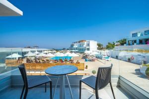a balcony with a table and chairs and a beach at Harmony Crest Resort in Kos